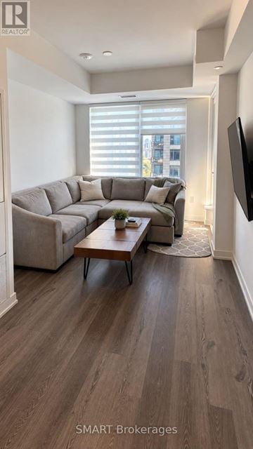 Mississauga (City Centre) condo for rent - A living room with a grey couch and a wooden coffee table.