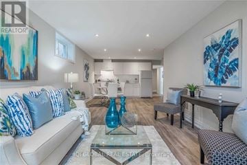 Oshawa (Mclaughlin) apartment for rent - A modern living room with a glass coffee table and a blue vase on it.