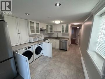 Vancouver apartment for rent - A kitchen with white cabinets and appliances.