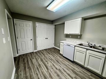 Louisville apartment for rent - A kitchen with white cabinets and a wood floor.
