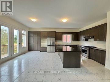 Richmond Hill apartment for rent - A spacious kitchen with a black countertop and brown cabinets.