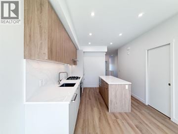 Coquitlam townhouse for rent - A modern kitchen with wooden cabinets and a white countertop.