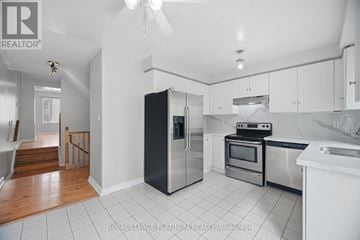 Brampton (Brampton West) townhouse for rent - A kitchen with white cabinets and a black fridge.