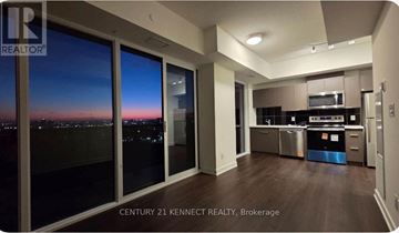 Toronto (Glenfield-Jane Heights) condo for rent - A kitchen with a view of the city at dusk.