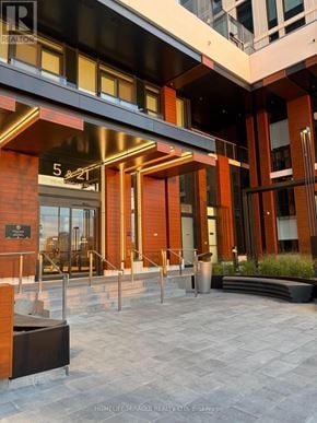 Vaughan (Concord) condo for rent - The entrance to a building with a glass door and a sign that reads "5 & 11".