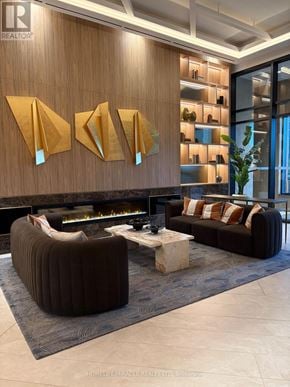 Vaughan (Concord) condo for rent - A modern living room with a fireplace and a large abstract art piece above it.