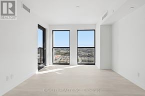 Toronto (Thorncliffe Park) condo for rent - A real estate listing image of a large, empty room with a view of a cityscape through the windows.