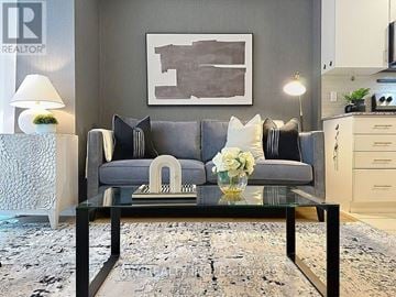 Toronto (Islington-City Centre West) townhouse for rent - A grey couch with a white vase of flowers on a glass table.