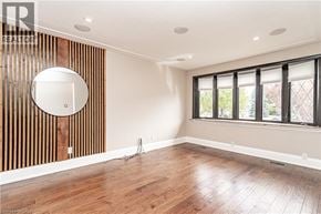 Hamilton apartment for rent - A room with wooden floors and a large round mirror on the wall.
