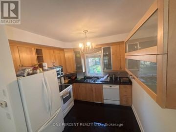 Toronto (Newtonbrook West) apartment for rent - A kitchen with wooden cabinets and a white refrigerator.