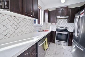 Brampton (Heart Lake East) townhouse for rent - A kitchen with dark brown cabinets and a white counter top.