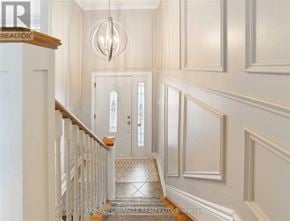 Clarington (Courtice) apartment for rent - A hallway with a chandelier, two doors, and a staircase.