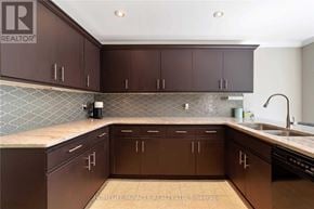 Clarington (Courtice) apartment for rent - A kitchen with brown cabinets and a tile backsplash.