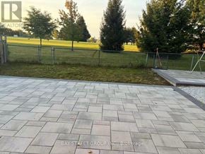Markham (Aileen-Willowbrook) apartment for rent - A paved walkway leads to a grassy area with a fence.