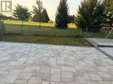 Markham (Aileen-Willowbrook) apartment for rent - A paved walkway leads to a grassy area with a fence.