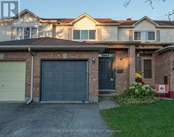 Ottawa townhouse for rent - A house with a garage and a sign in front of it.