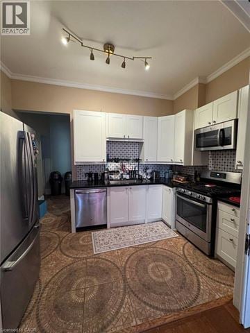 Hamilton apartment for rent - A kitchen with a refrigerator, oven, and microwave.