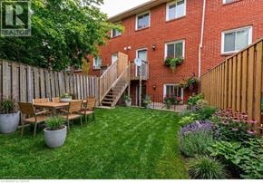 Hamilton townhouse for rent - A backyard with a wooden deck and a lawn.