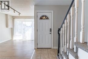 Hamilton townhouse for rent - A white door with a window above it and a staircase to the right.
