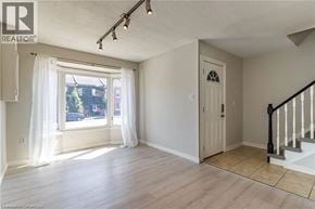 Hamilton townhouse for rent - A room with a window, a door, and a staircase.