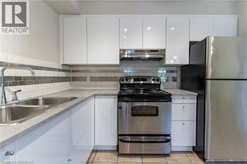 Hamilton townhouse for rent - A modern kitchen with white cabinets and stainless steel appliances.