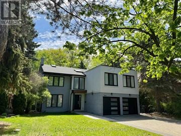 Mississauga (Erin Mills) apartment for rent - A modern two-story house with a garage is surrounded by trees and has a well-maintained lawn.