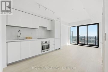 Toronto (Thorncliffe Park) condo for rent - A white kitchen with a view of the city.