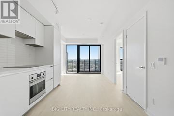 Toronto (Thorncliffe Park) condo for rent - A spacious kitchen with white cabinets and a view of the city.