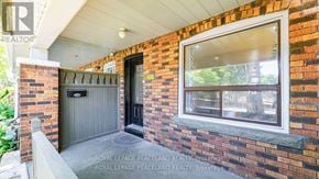 Toronto (Greenwood-Coxwell) apartment for rent - A brick house with a black door and a window.