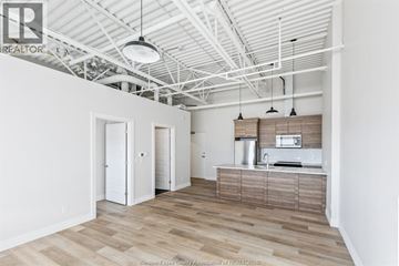 Lasalle apartment for rent - A spacious kitchen with white cabinets and a wooden island.