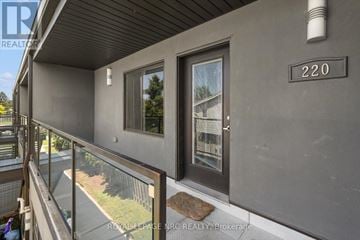 St. Catharines (Lakeport) multi-family for rent - A balcony of a house with a glass railing and a mat on the floor.