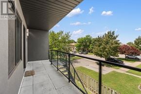 St. Catharines (Lakeport) multi-family for rent - A balcony with a metal railing and a view of a street with cars and houses.