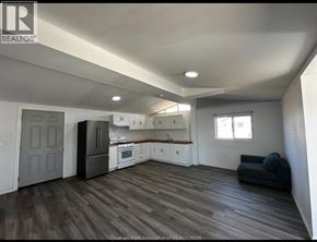 Shrewsbury apartment for rent - A kitchen with white cabinets and a black refrigerator.