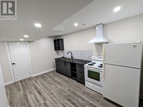 Newmarket (Huron Heights-Leslie Valley) apartment for rent - A kitchen with white appliances and a wooden floor.