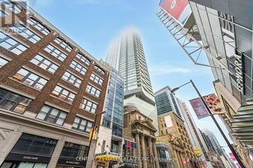 Toronto (Church-Yonge Corridor) condo for rent - A street view of a city with a tall building in the background.