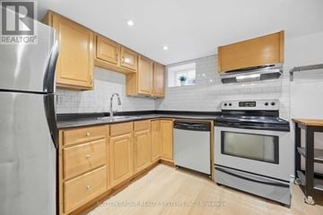 Toronto (Greenwood-Coxwell) fourplex for rent - A kitchen with wooden cabinets and a black refrigerator.