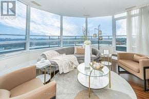 Markham (Unionville) condo for rent - A living room with a glass table and a view of the city.