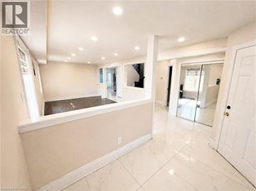 Kitchener apartment for rent - A spacious room with a kitchen area and a tiled floor.
