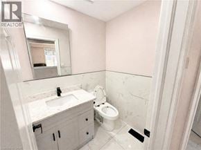 Kitchener apartment for rent - A bathroom with a sink, toilet, and mirror.