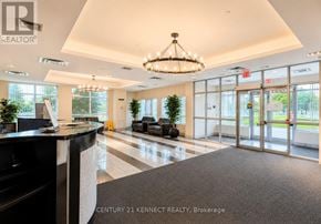 Toronto (Wexford-Maryvale) condo for rent - The lobby of a building with a black reception desk and a chandelier hanging from the ceiling.