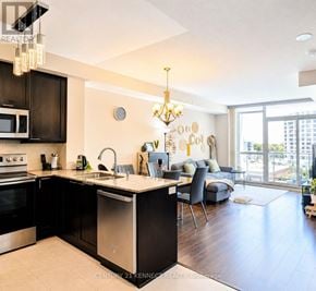 Toronto (Wexford-Maryvale) condo for rent - A modern kitchen with dark wood cabinets and stainless steel appliances.
