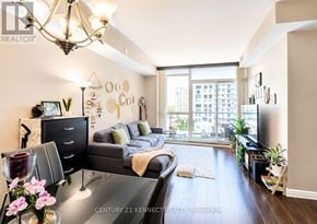 Toronto (Wexford-Maryvale) condo for rent - A well-lit living room with a grey couch and a chandelier.