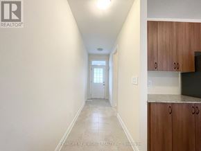 Georgina (Sutton & Jackson's Point) apartment for rent - A hallway with a door at the end and a kitchen area to the right.