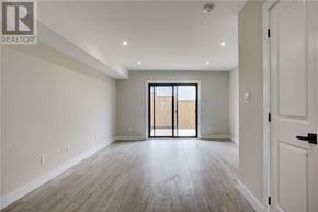 Azilda apartment for rent - A spacious room with a sliding door and wooden flooring.