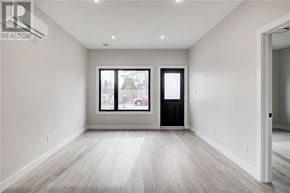 Azilda apartment for rent - A spacious room with a large window and a door.