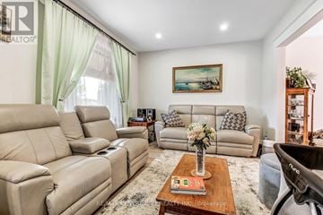 St. Thomas apartment for rent - A living room with a large beige sofa and a coffee table with a vase of flowers on it.