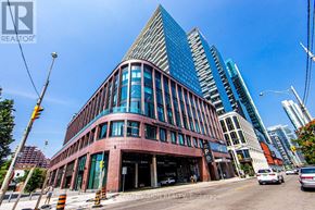 Toronto (Waterfront Communities) condo for rent - A modern building with a curved facade is the focal point of the image.