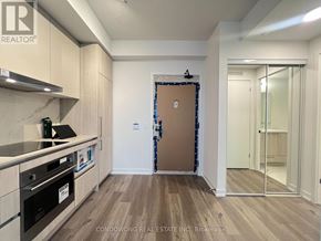 Vaughan (Vaughan Corporate Centre) condo for rent - A kitchen with a brown door and wooden floors.