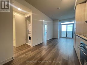 Vaughan (Vaughan Corporate Centre) condo for rent - A spacious kitchen and living room with wood flooring and a washer and dryer in the corner.