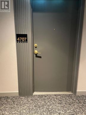 Vaughan (Vaughan Corporate Centre) condo for rent - A silver door with a gold handle and a sign on the wall that says 4707.